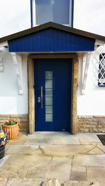 neu eingebaute blaue Tür mit blauen Spitzvordach